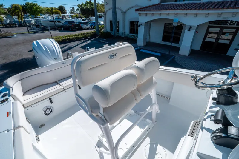 Slide: The Image of 2025 Sea Hunt Ultra 235 SE boat interior with white seating and steering wheel. - 16