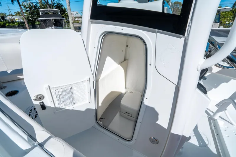 Slide: The Image of 2025 Sea Hunt Ultra 235 SE boat interior storage compartment with open door. - 18