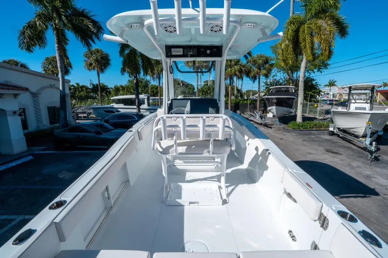 Slide: The Image of 2025 Sea Hunt Ultra 235 SE boat interior with seating, parked outdoors under palm trees. - 9