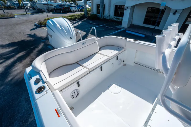 Slide: The Image of 2025 Sea Hunt Ultra 235 SE boat interior with cushioned seating and rod holders. - 11