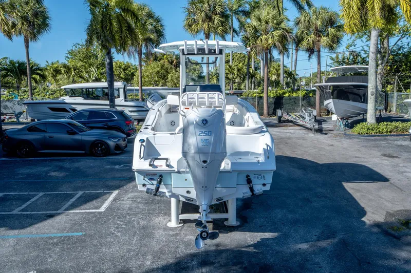 Slide: The Image of 2025 Sea Hunt Ultra 235 SE boat parked, surrounded by palm trees and vehicles. - 3