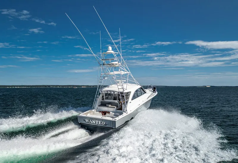 Slide: The Image of 2012 Cabo 44 HTX yacht cruising on open water under clear blue skies. - 3