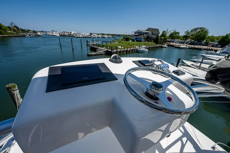 Slide: The Image of 2012 Cabo 44 HTX yacht helm with scenic waterfront view. - 30