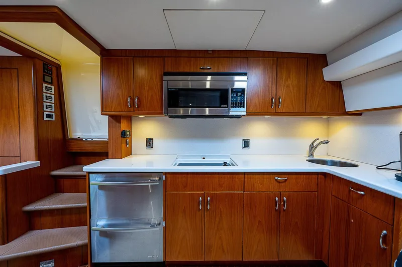 Slide: The Image of Luxurious 2012 Cabo 44 HTX yacht kitchen with wood cabinetry and modern appliances. - 5