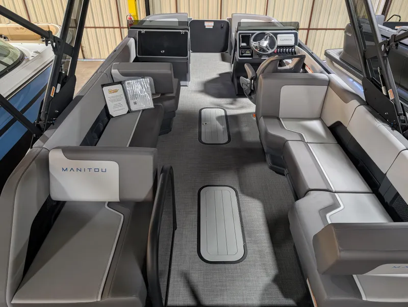 Slide: The Image of 2025 Manitou Cruise boat interior with modern seating and steering console. - 2