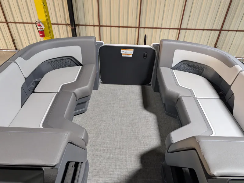 Slide: The Image of 2025 Manitou Cruise boat interior with gray seating and carpeted floor. - 4