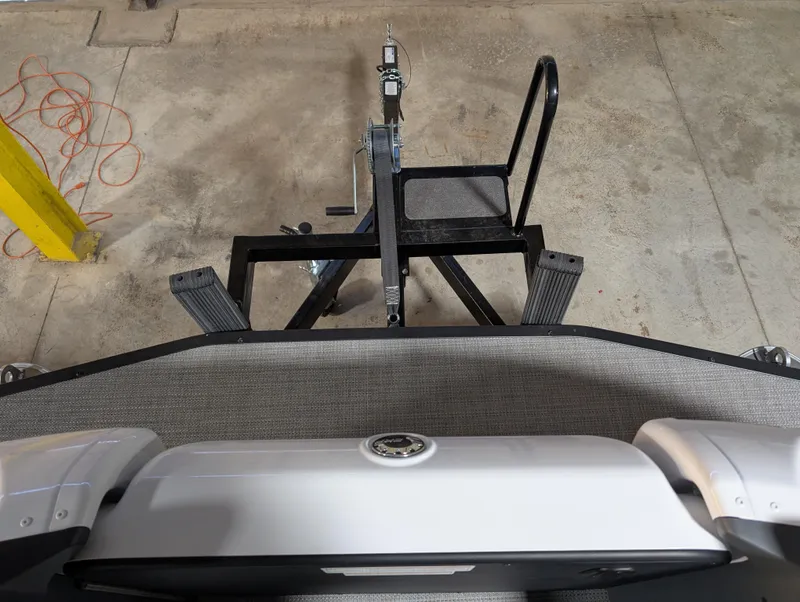 Slide: The Image of 2025 Manitou Cruise boat on trailer in garage, viewed from above. - 5