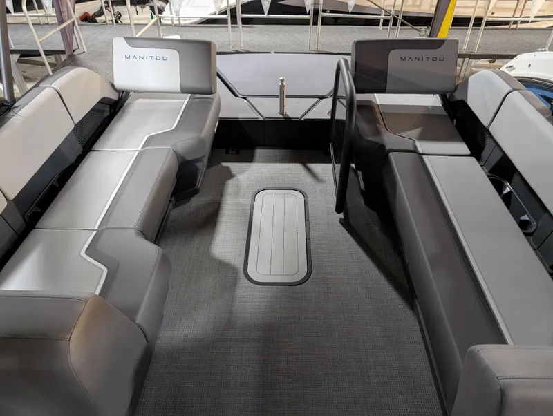 Slide: The Image of 2025 Manitou Cruise boat interior with gray seating and carpeted floor. - 8