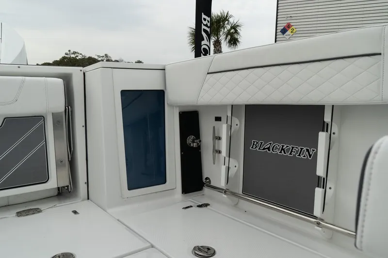 Slide: The Image of 2023 Blackfin 272 DC boat interior with sleek white design and storage compartments. - 16