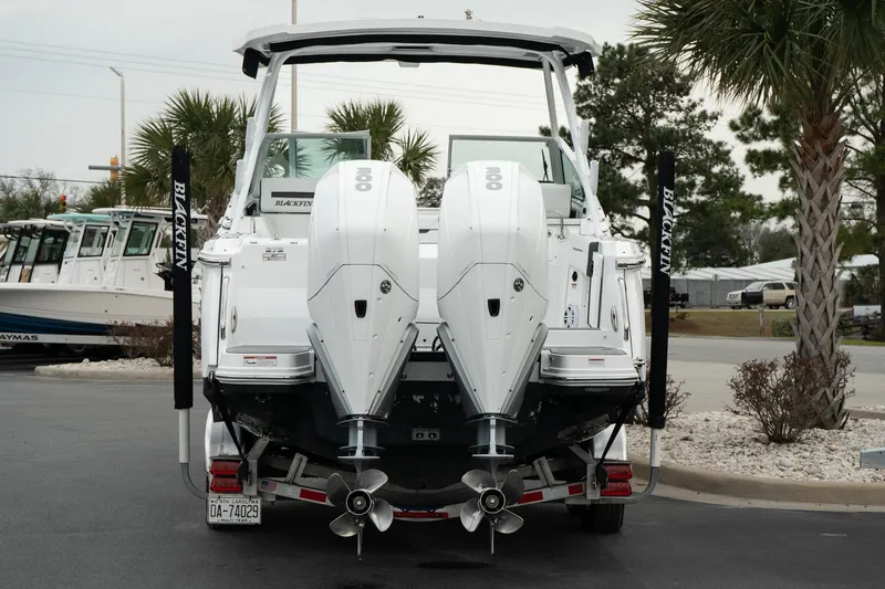 Slide: The Image of 2023 Blackfin 272 DC boat with dual outboard engines, parked near palm trees. - 8