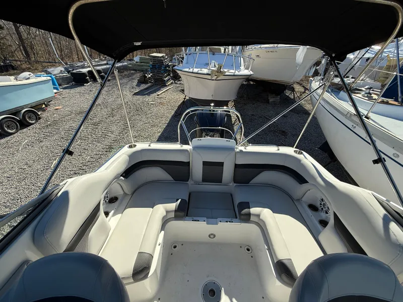 Slide: The Image of 2018 Hurricane SunDeck 2486 OB boat interior with seating, parked among other boats. - 10