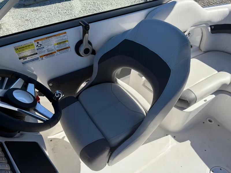 Slide: The Image of 2018 Hurricane SunDeck 2486 OB boat interior with gray captain's chair and steering wheel. - 16