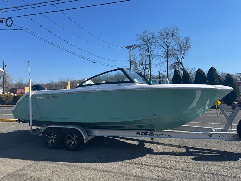 The Image of 2025 Aquasport 22AS Dual Console boat on trailer, parked outdoors under clear blue sky. - 0