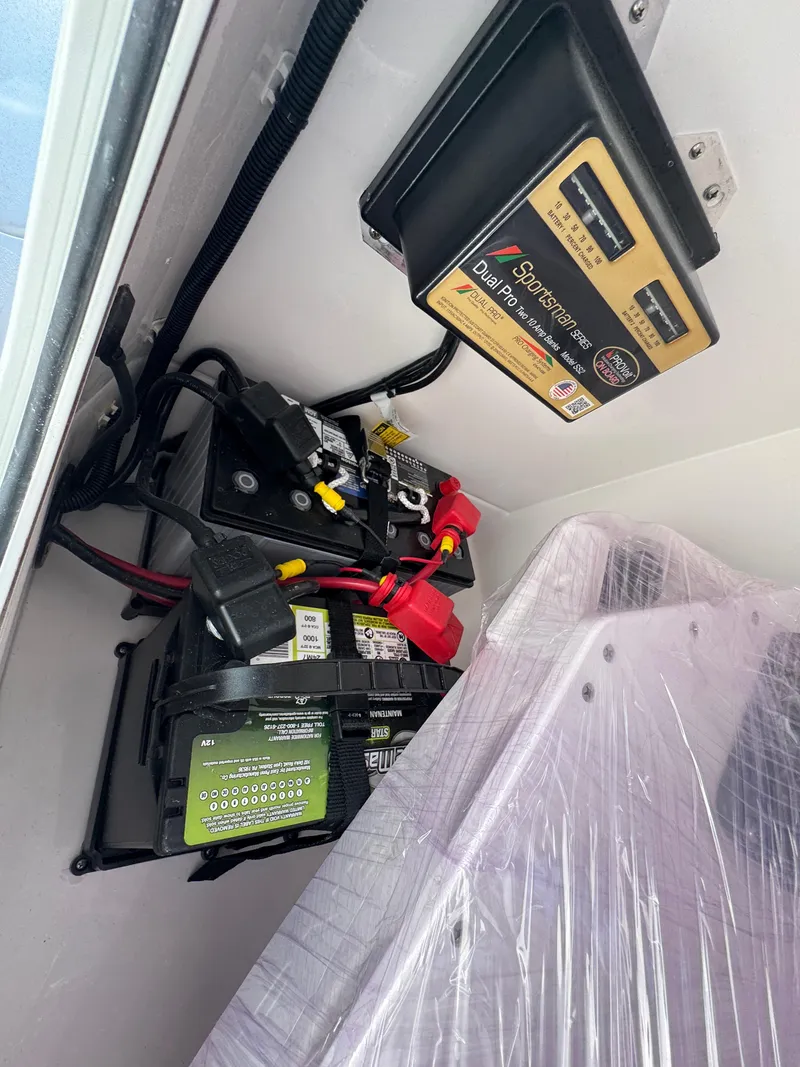 Slide: The Image of 2025 Aquasport 22AS Dual Console boat battery and charger setup. - 12