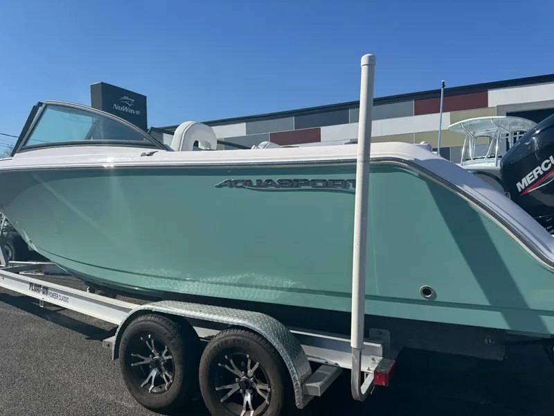 Slide: The Image of 2025 Aquasport 22AS Dual Console boat on trailer, side view, in a parking lot. - 4