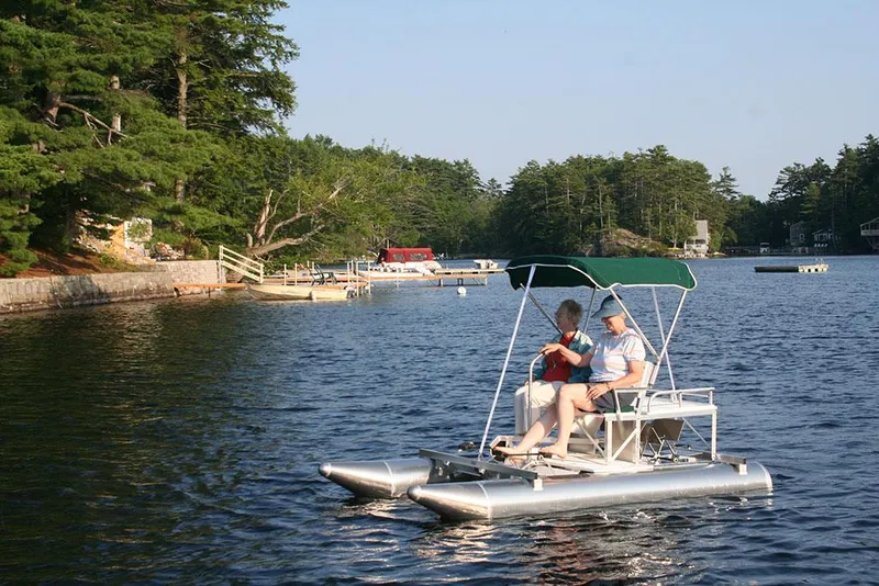 Slide: The Image of 2024 Aqua Cycle AC15W on a serene lake with two people enjoying a ride. - 4