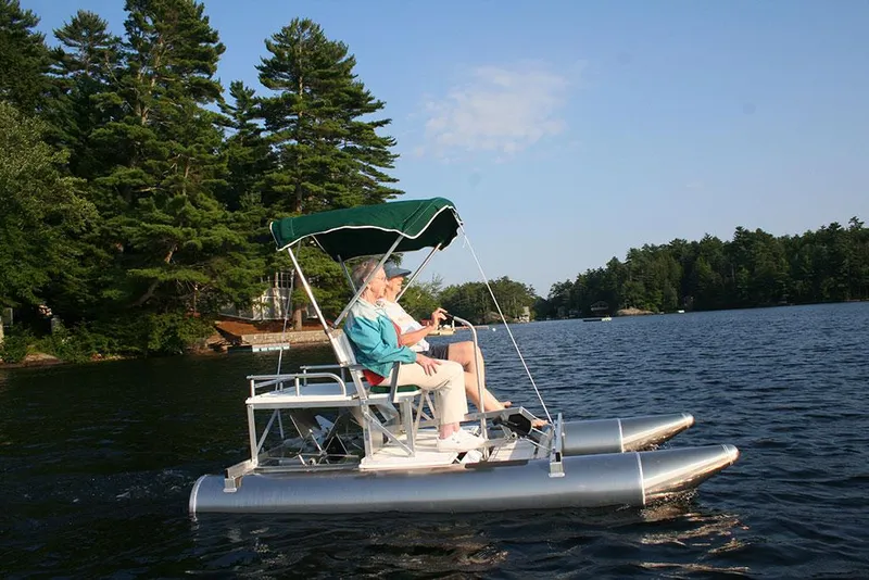 Slide: The Image of 2024 Aqua Cycle AC15W pedal boat on a serene lake with lush trees. - 6