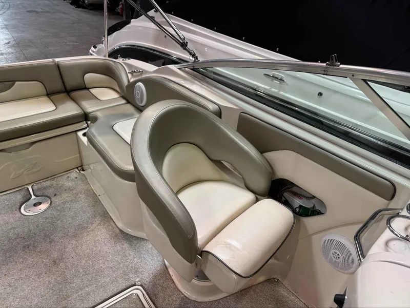 Slide: The Image of 2005 Sea Ray 270 Sundeck interior with beige seating and carpeted flooring. - 8
