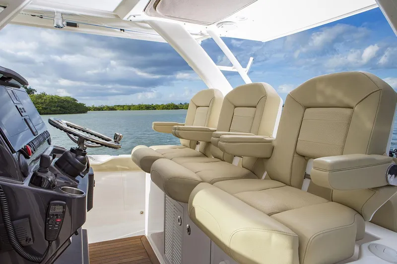 Slide: The Image of 2019 Pursuit S 408 Sport boat docked in a marina, reflecting on calm water. - 14