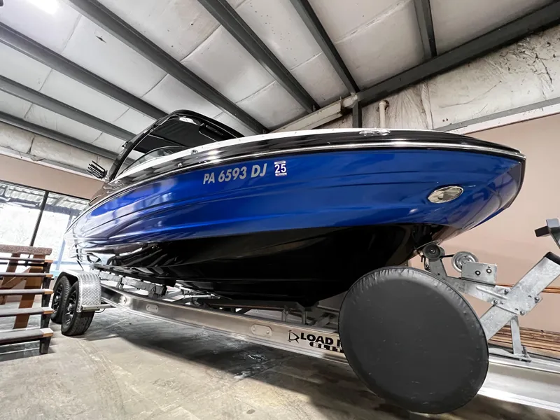 Slide: The Image of 2013 Crownline Eclipse E4 boat in blue, on a trailer, indoors. - 1