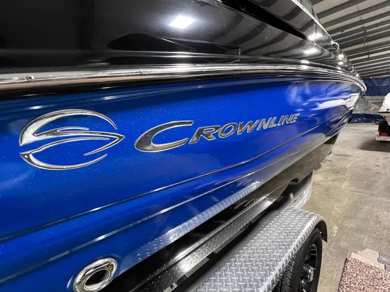 Slide: The Image of 2013 Crownline Eclipse E4 boat with blue and black exterior in a garage. - 2