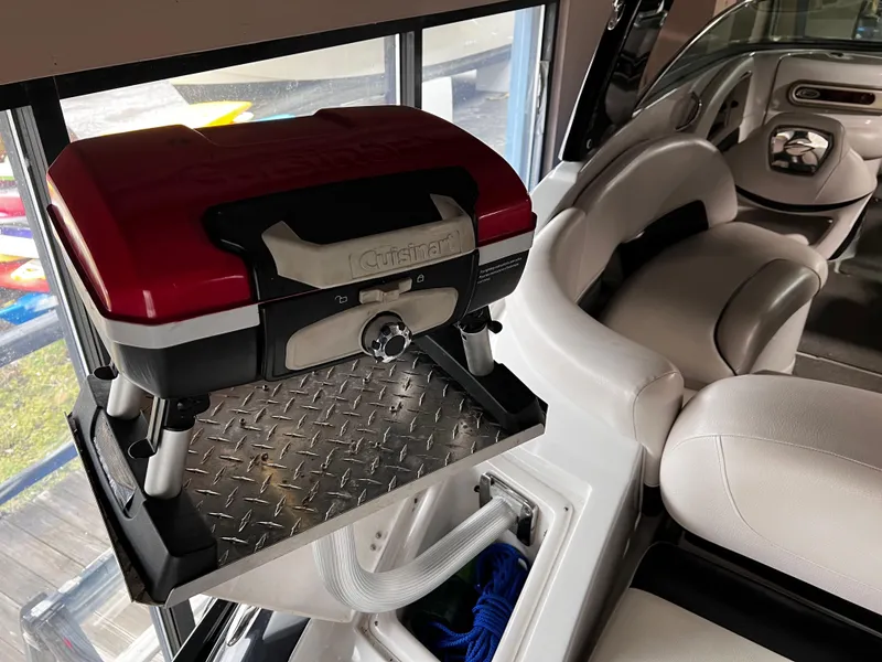 Slide: The Image of 2013 Crownline Eclipse E4 interior with mounted portable grill and white seating. - 27