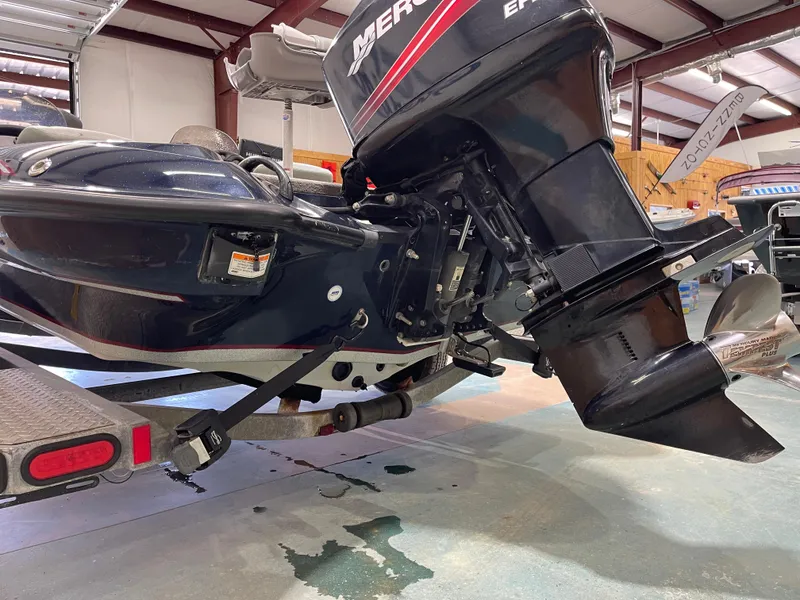 Slide: The Image of 2009 Triton 18 HP Explorer boat with Mercury outboard motor in a garage setting. - 14