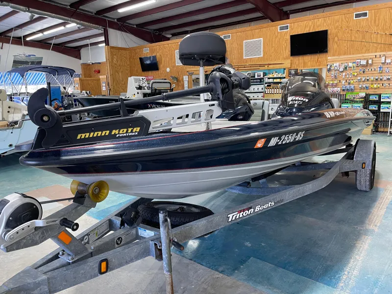 Slide: The Image of 2009 Triton 18 HP Explorer boat on trailer in showroom, featuring Minn Kota motor. - 9