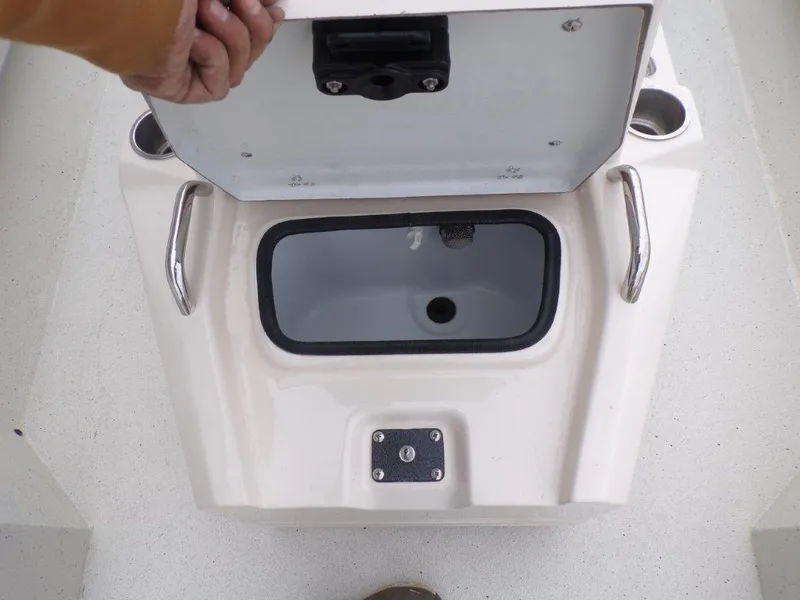 Slide: The Image of 2025 Xpress H20BAY boat storage compartment with open lid and cup holders. - 11