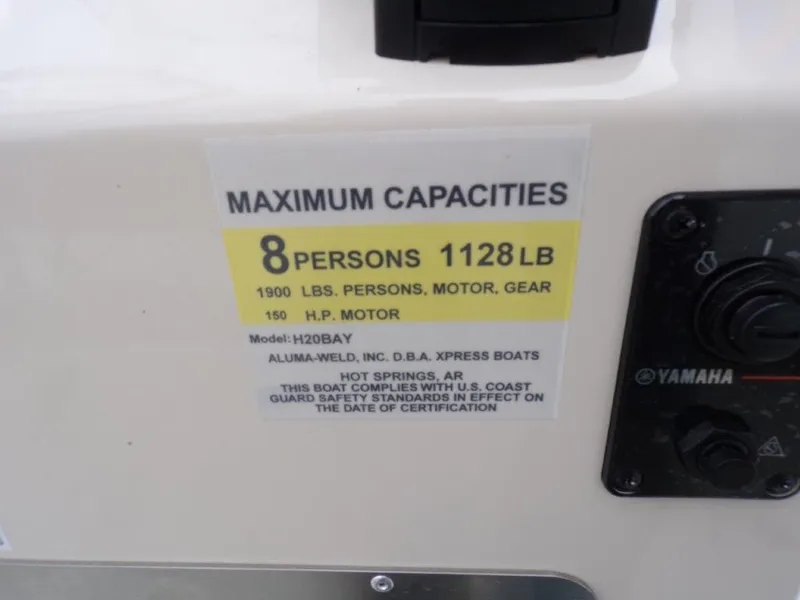 Slide: The Image of 2025 Xpress H20BAY boat capacity label, 8 persons, 1128 lbs, 150 HP motor. - 4