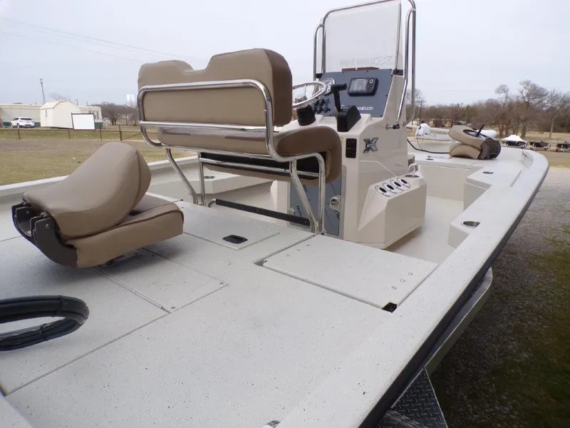 Slide: The Image of 2025 Xpress H20BAY boat interior with beige seating and steering console. - 5
