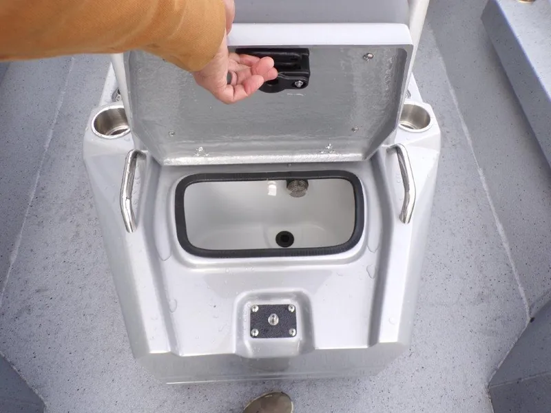Slide: The Image of 2025 Xpress H20BAY boat storage compartment with open lid and cup holders. - 13