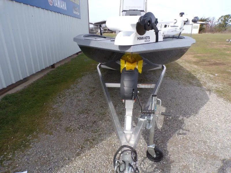 Slide: The Image of 2025 Xpress H20BAY boat on trailer with Minn Kota motor, parked outdoors. - 6