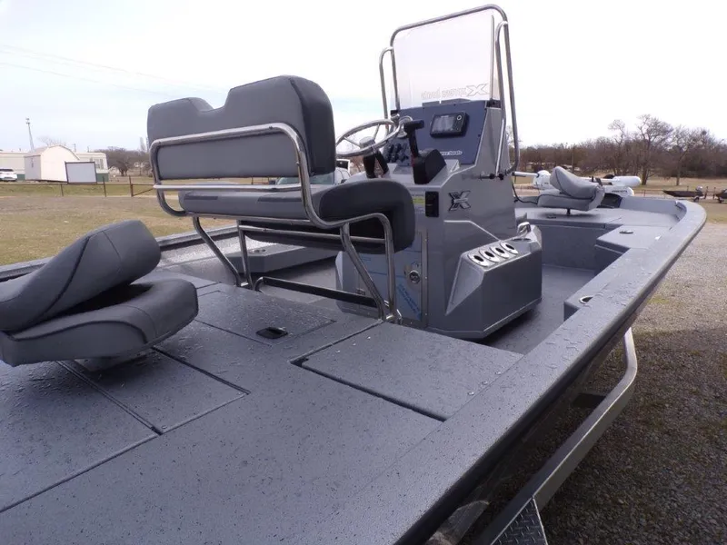 Slide: The Image of 2025 Xpress H20BAY boat with seating and console, parked outdoors. - 7