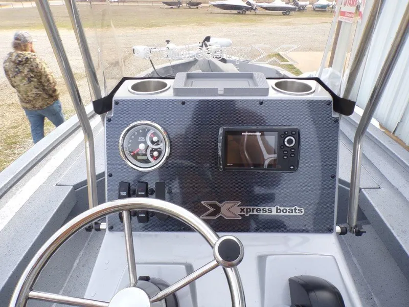 Slide: The Image of 2025 Xpress H20BAY boat dashboard with steering wheel and navigation display. - 9