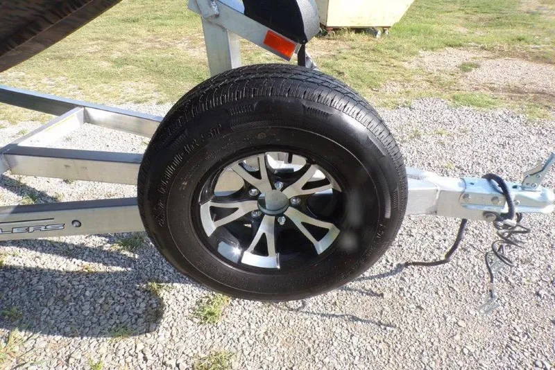 Slide: The Image of Trailer wheel on Xpress XP200, 2026 model, parked on gravel. - 12