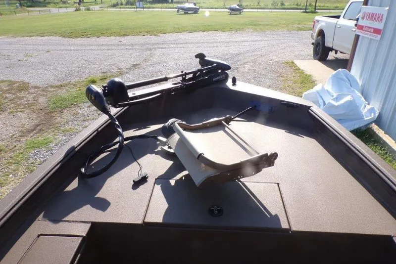 Slide: The Image of 2026 Xpress XP200 boat interior with trolling motor and seating, parked outdoors. - 22