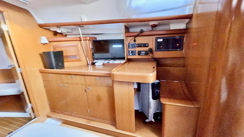 Slide: The Image of 2006 Beneteau 393 yacht interior with wooden cabinetry and navigation equipment. - 35