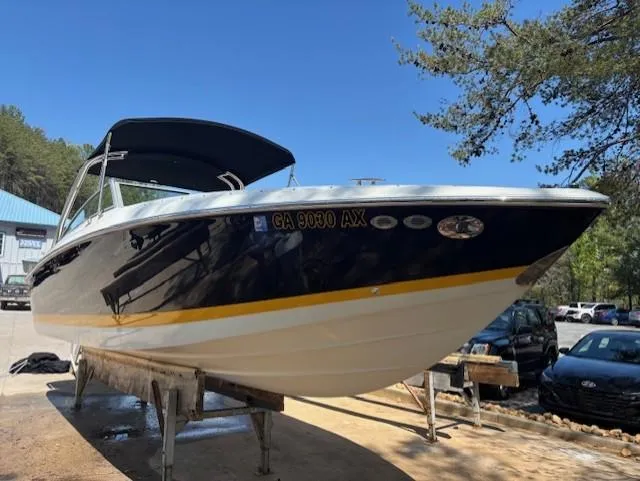 The Image of 2005 Cobalt 272 boat on a stand, black and white hull, sunny day. - 0
