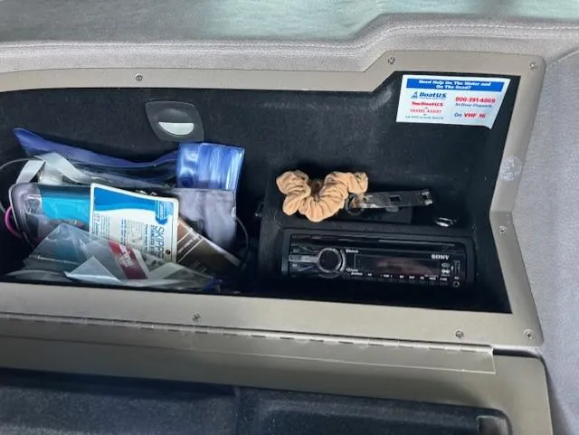 Slide: The Image of Storage compartment in a 2005 Cobalt 272 boat with various items and a Sony stereo. - 13