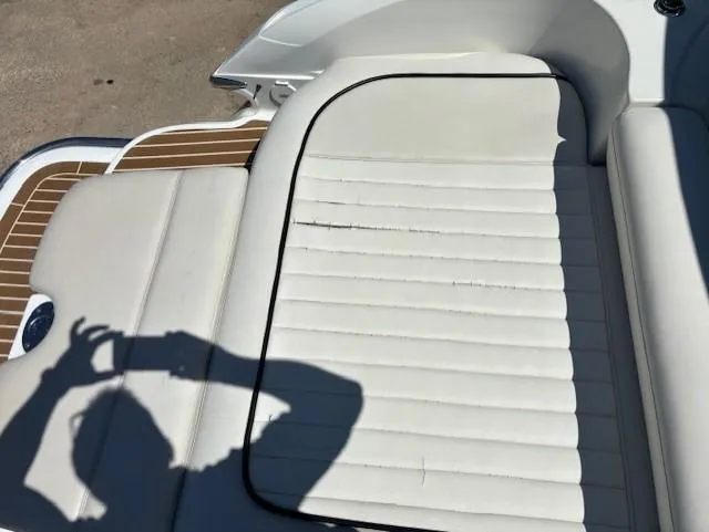 Slide: The Image of 2005 Cobalt 272 boat with white leather seating and wood accents, shadow of person taking photo. - 18
