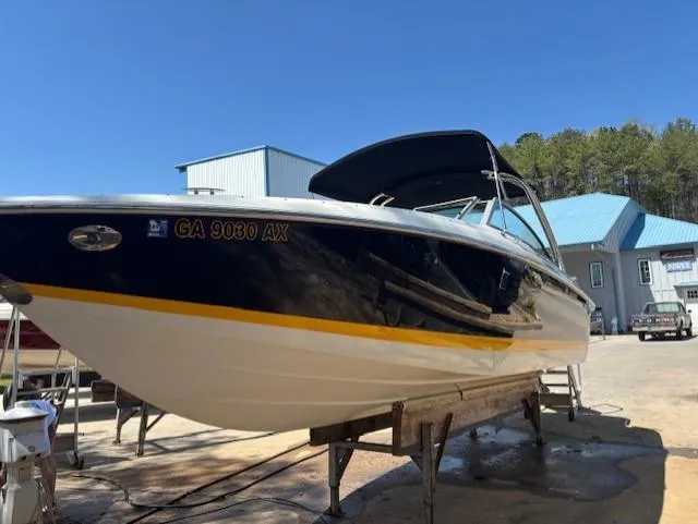 Slide: The Image of 2005 Cobalt 272 boat on a stand, blue and white hull, sunny day. - 2