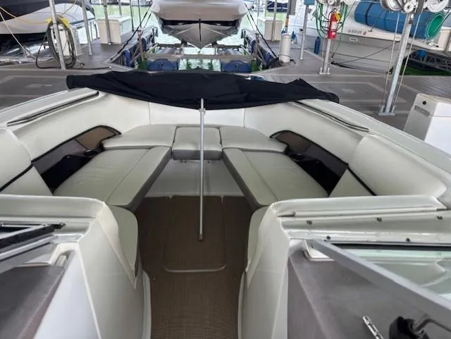 Slide: The Image of 2005 Cobalt 272 boat interior with white seating in a marina setting. - 20