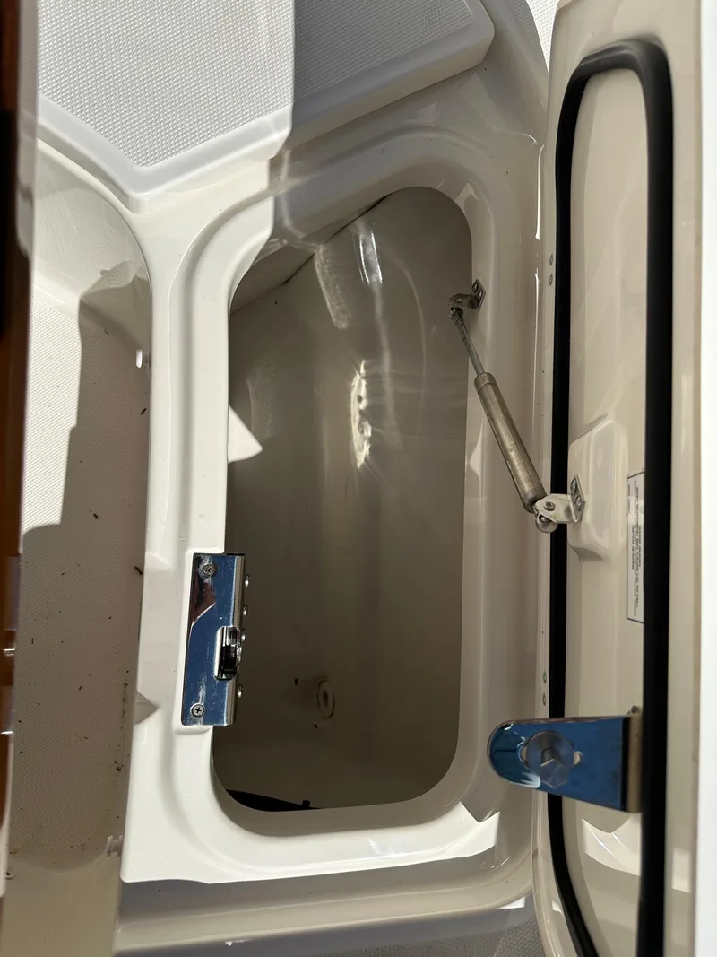 Slide: The Image of 2021 Boston Whaler Realm 380 storage compartment with open hatch and hydraulic support. - 13