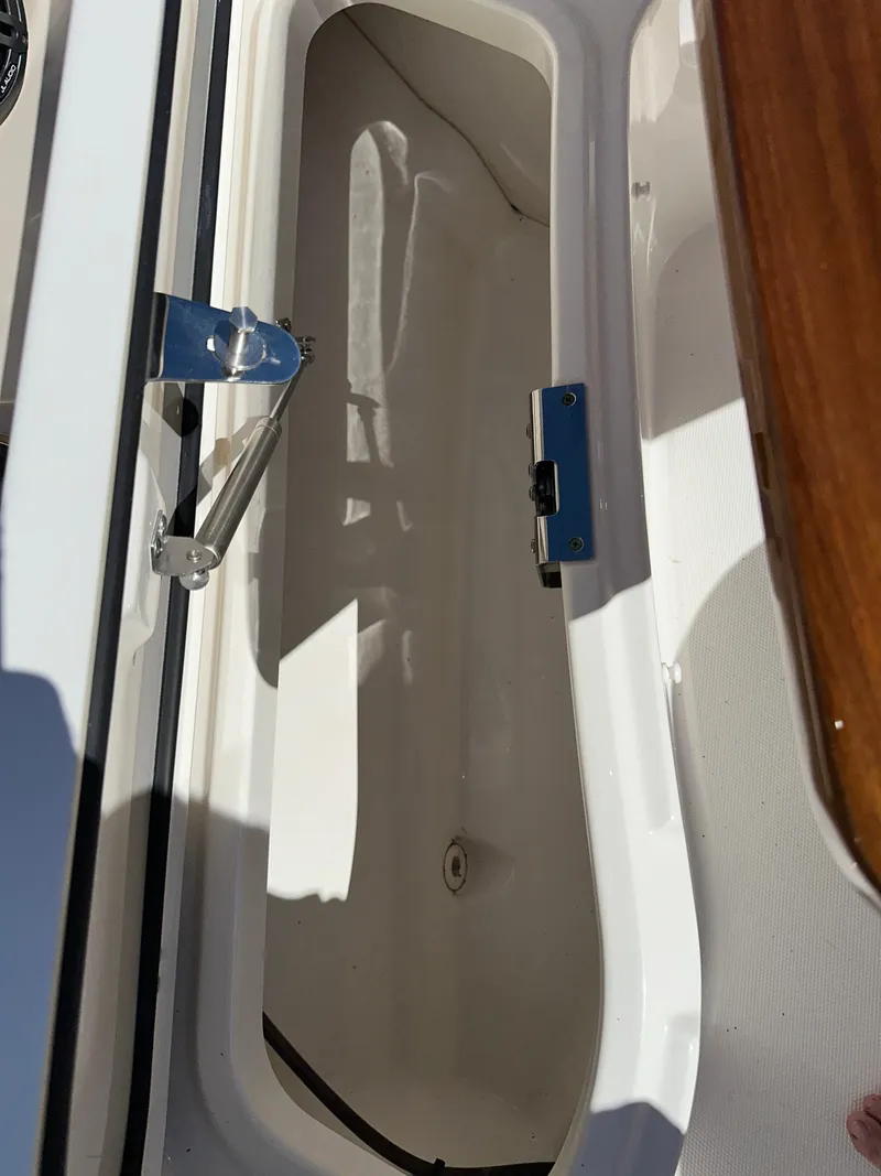 Slide: The Image of Open storage compartment on a 2021 Boston Whaler Realm 380 boat. - 16