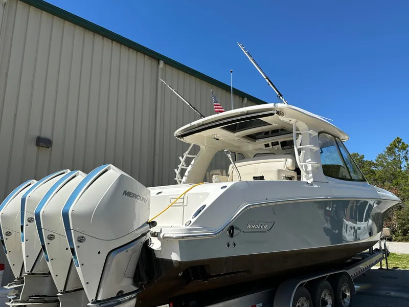 Slide: The Image of 2021 Boston Whaler Realm 380 boat with triple Mercury engines on a trailer. - 2