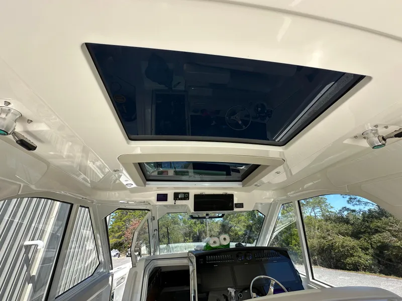Slide: The Image of Interior view of 2021 Boston Whaler Realm 380 boat with sunroof and control panel. - 29