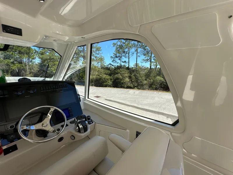Slide: The Image of Interior view of 2021 Boston Whaler Realm 380 boat cockpit with steering wheel and controls. - 31