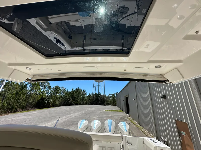 Slide: The Image of 2021 Boston Whaler Realm 380 boat interior with sunroof and outboard motors. - 33