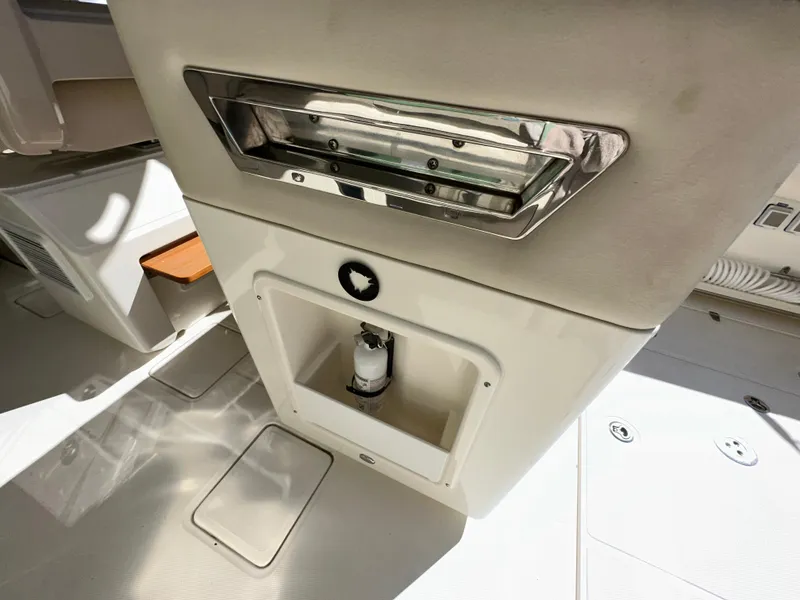 Slide: The Image of 2021 Boston Whaler Realm 380 interior detail, featuring storage compartment and stainless steel accents. - 34